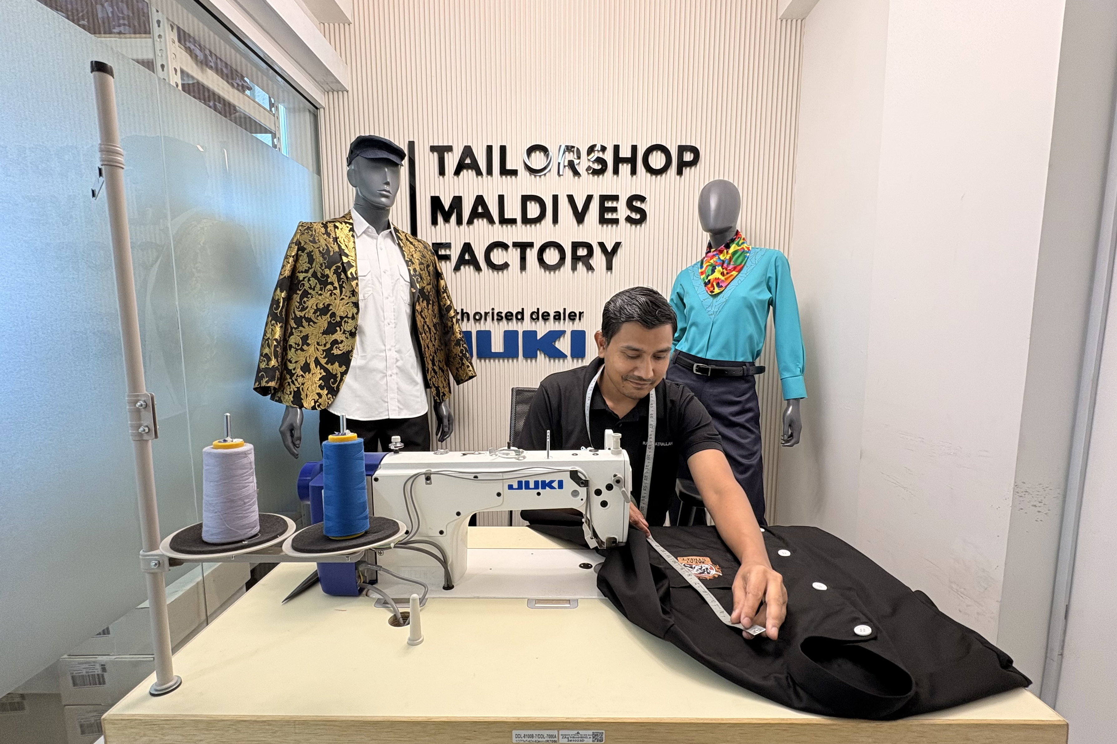 A Tailorshop tailor at a JUKI industrial machine on the factory floor